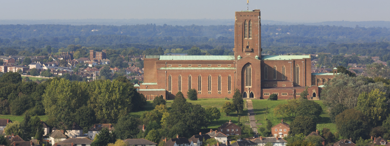 View of an historic building with a field and trees surrounding it