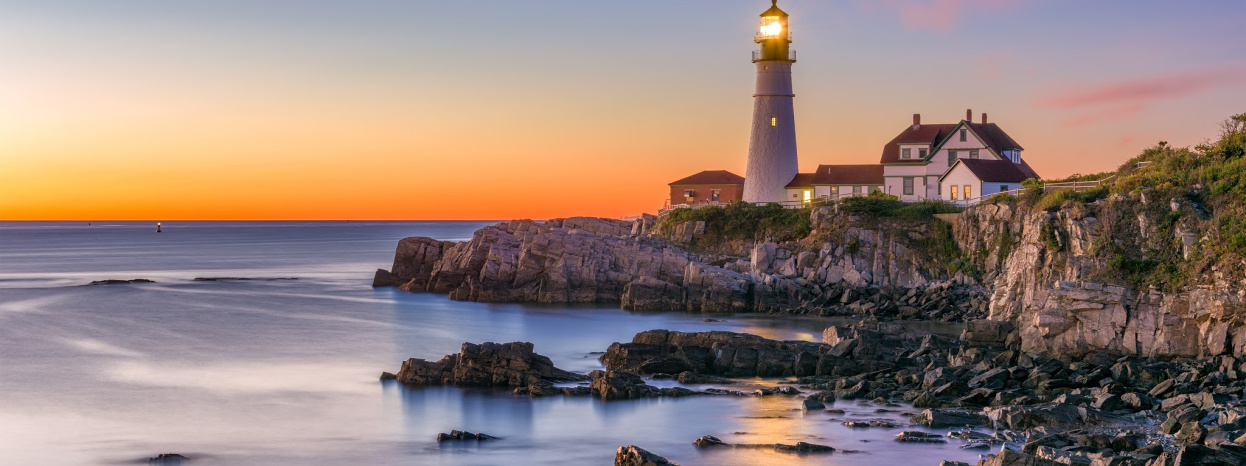 Lighthouse by the ocean at sunset