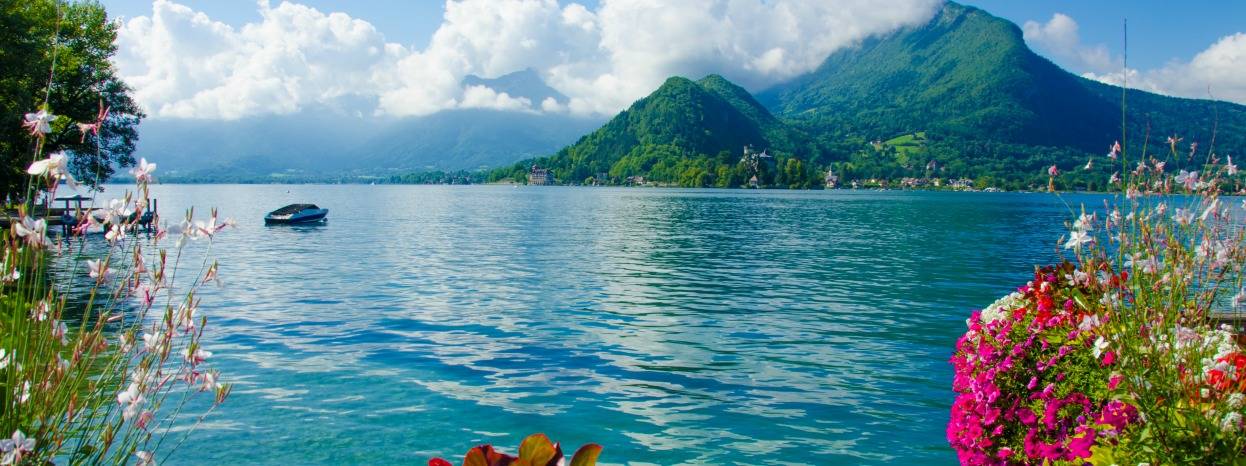 View of Lake Como, Italy. Mountains in the background and a small boat on the lake.