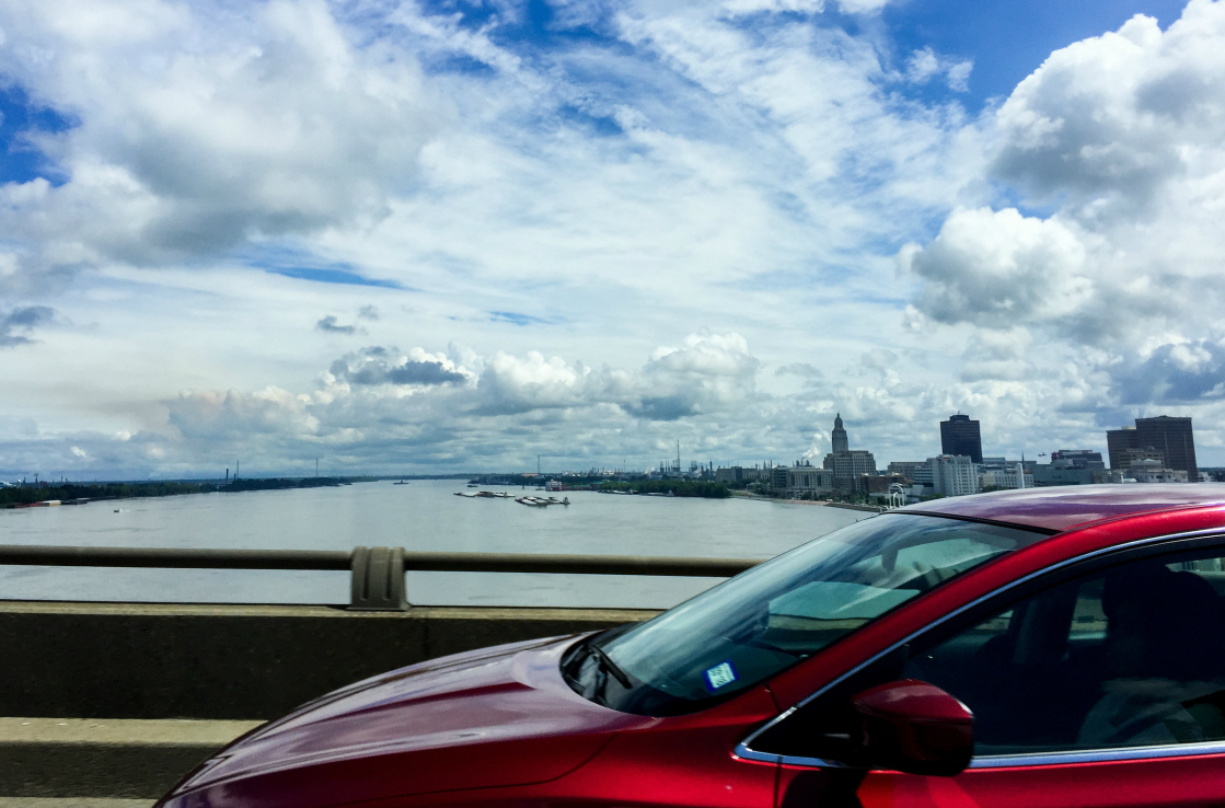 Red car crossing a city bridge