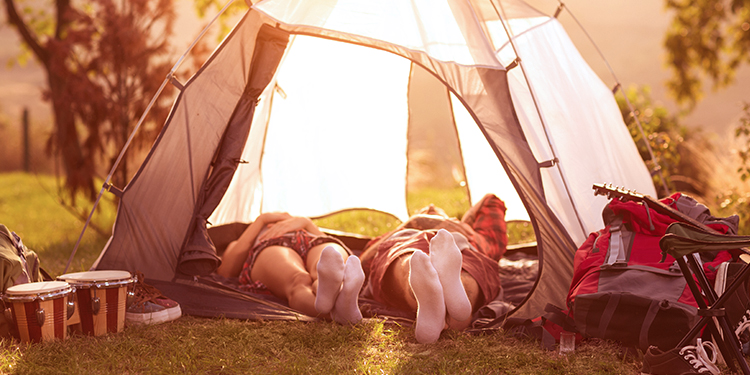 A couple lies down in a camping tent on a sunny afternoon. A couple lies down in a camping tent on a sunny afternoon.