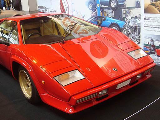 Red 1982 Lamborghini Countach LP500 S on display in a car showroom