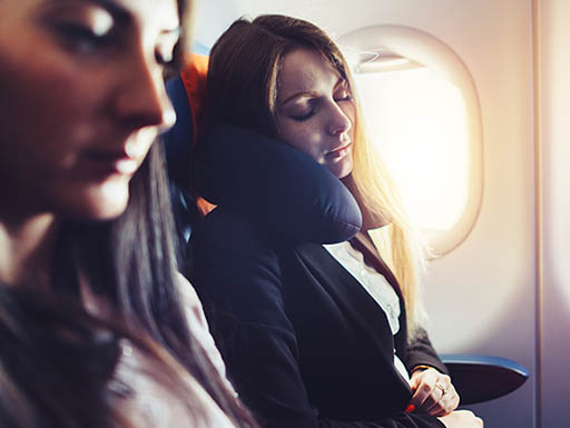 Woman sleeping with a travel pillow on an air plane Woman sleeping with a travel pillow on an air plane