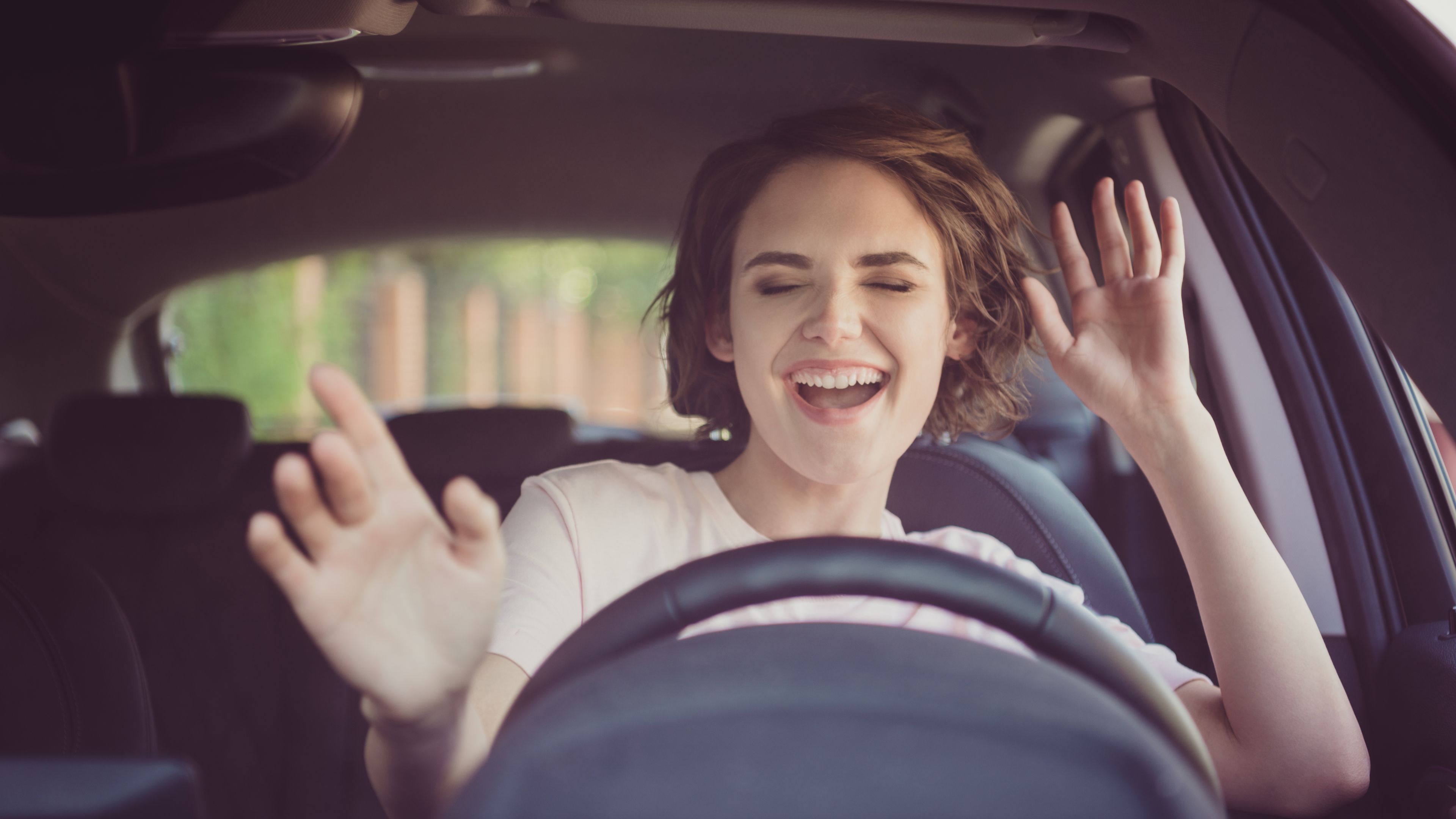 Woman singing and dancing in the car.