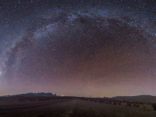 A nighttime photo of Big Bend National Park underneath a sky full of stars, including the Milky Way Galaxy