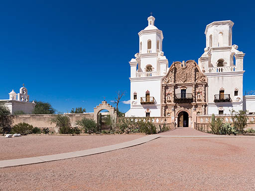 White building of Mission San Xavier del Bac against a bright blue sky in Tucson, Arizona