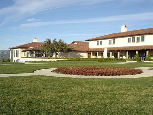 External view of Ronald Reagan Presidential Library and Museum in Simi Valley, CA, on sunny day – a white building with brown roof and beautiful landscaping