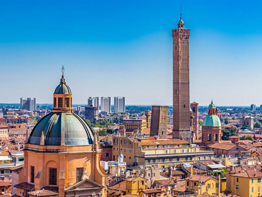 Panoramic view of the downtown buildings and rooftops of Bologna, Italy on a clear, sunny afternoon.