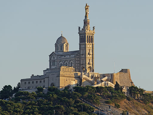 Marseille’s Notre-Dame de la Garde, an ornate church drenched in the late afternoon sun, is situated above the entire city of Marseille. Marseille’s Notre-Dame de la Garde, an ornate church drenched in the late afternoon sun, is situated above the entire city of Marseille.