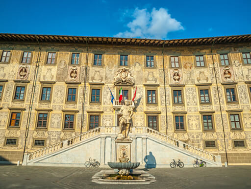 The Palazzo della Carovana with a statue of the Grand Duke of Tuscany in the foreground on a sunny afternoon in Pisa, Italy. The Palazzo della Carovana with a statue of the Grand Duke of Tuscany in the foreground on a sunny afternoon in Pisa, Italy.