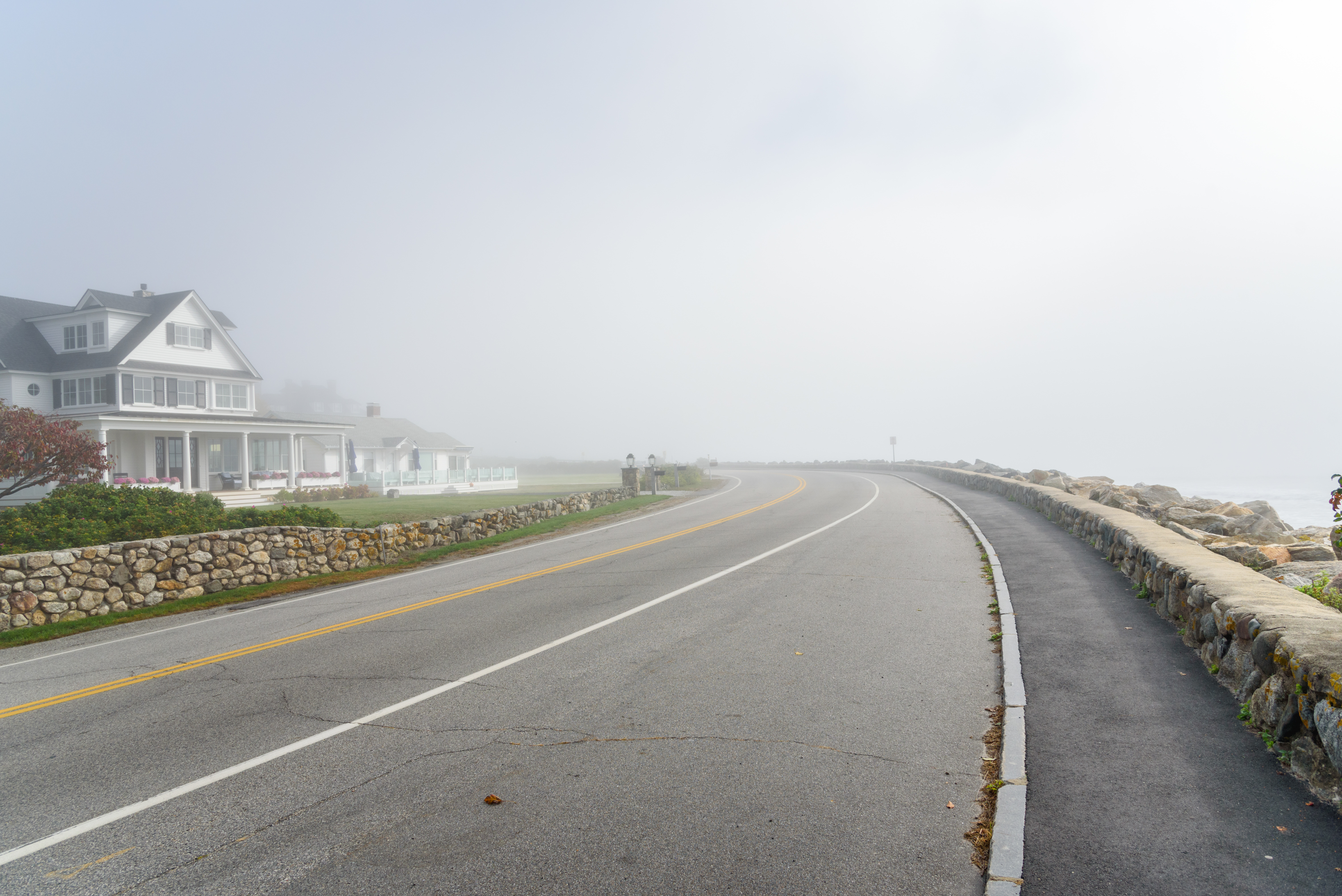 Deserted winding coastal road shrouded in fog on a fall morning. Seacoast region NH, USA. Seacoast Region Hampton beach, NH, USA.