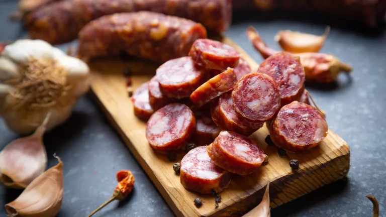 Chorizo on a wooden board with garlic.