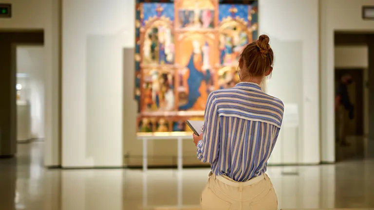 Woman sat in art gallery looking at artwaork