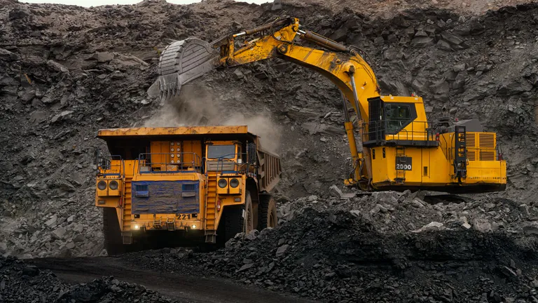 Yellow construction vehicle and digger in a quarry