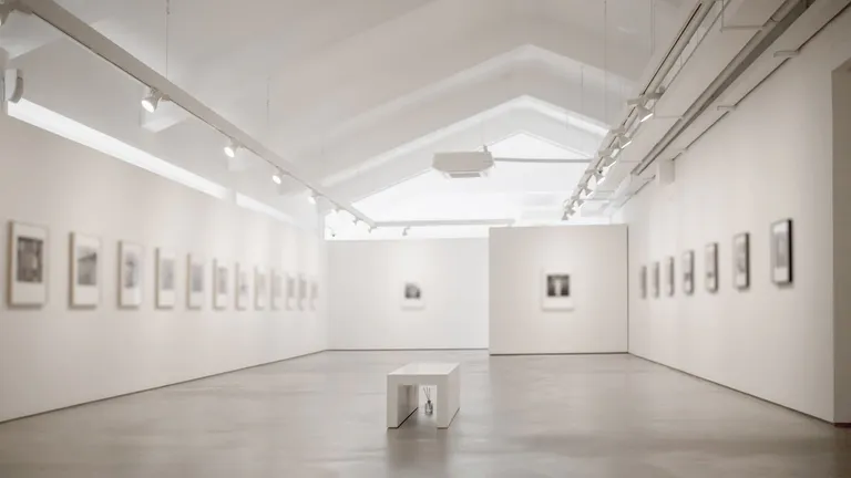 White-walled art gallery with a bench in the centre