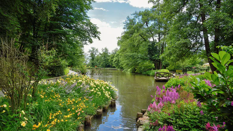 Public garden with flower beds either side of a river